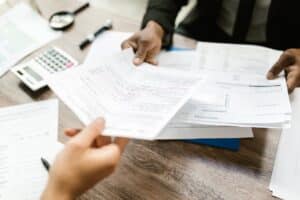 Business people preparing tax returns with papers and a calculator representing an article about tips to avoid small business IRS audits.