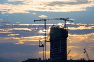 A building under construction with cranes in the sky. Image representing business growth as one of the main benefits of the construction business line of credit.